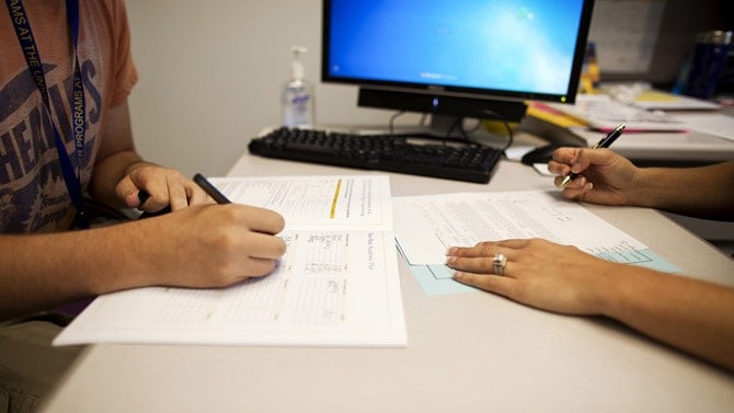 Advisor meets with students and writes on paper