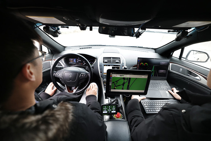 Xintao Yan and Haojie Zhu, both civil engineering PhD students, prepare to take one of the autonomous vehicles for a test run at Mcity. Photo: Brenda Ahearn/Michigan Engineering